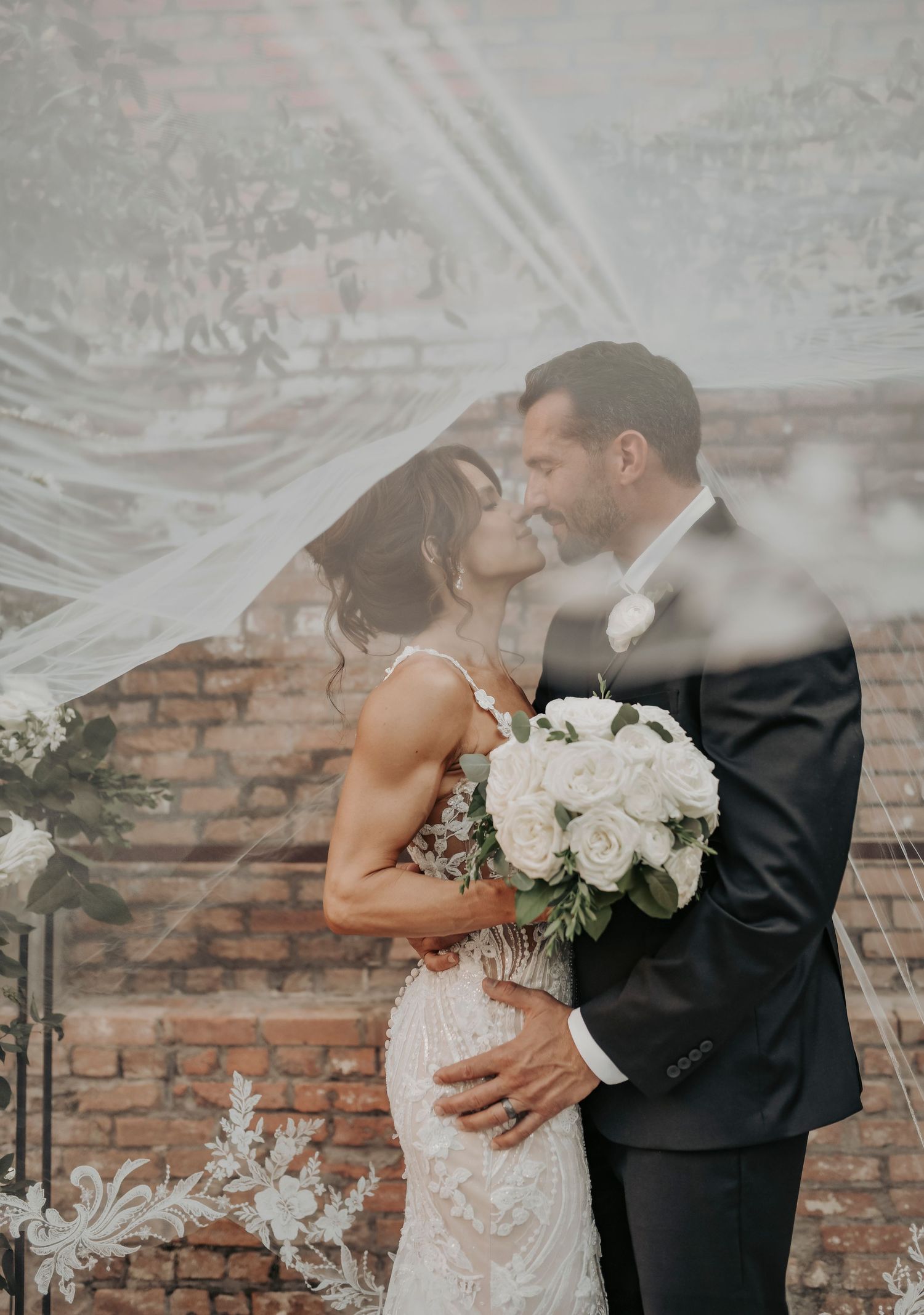 joel and megan kiss under the veil at their wedding at the mkcinney cotton mill