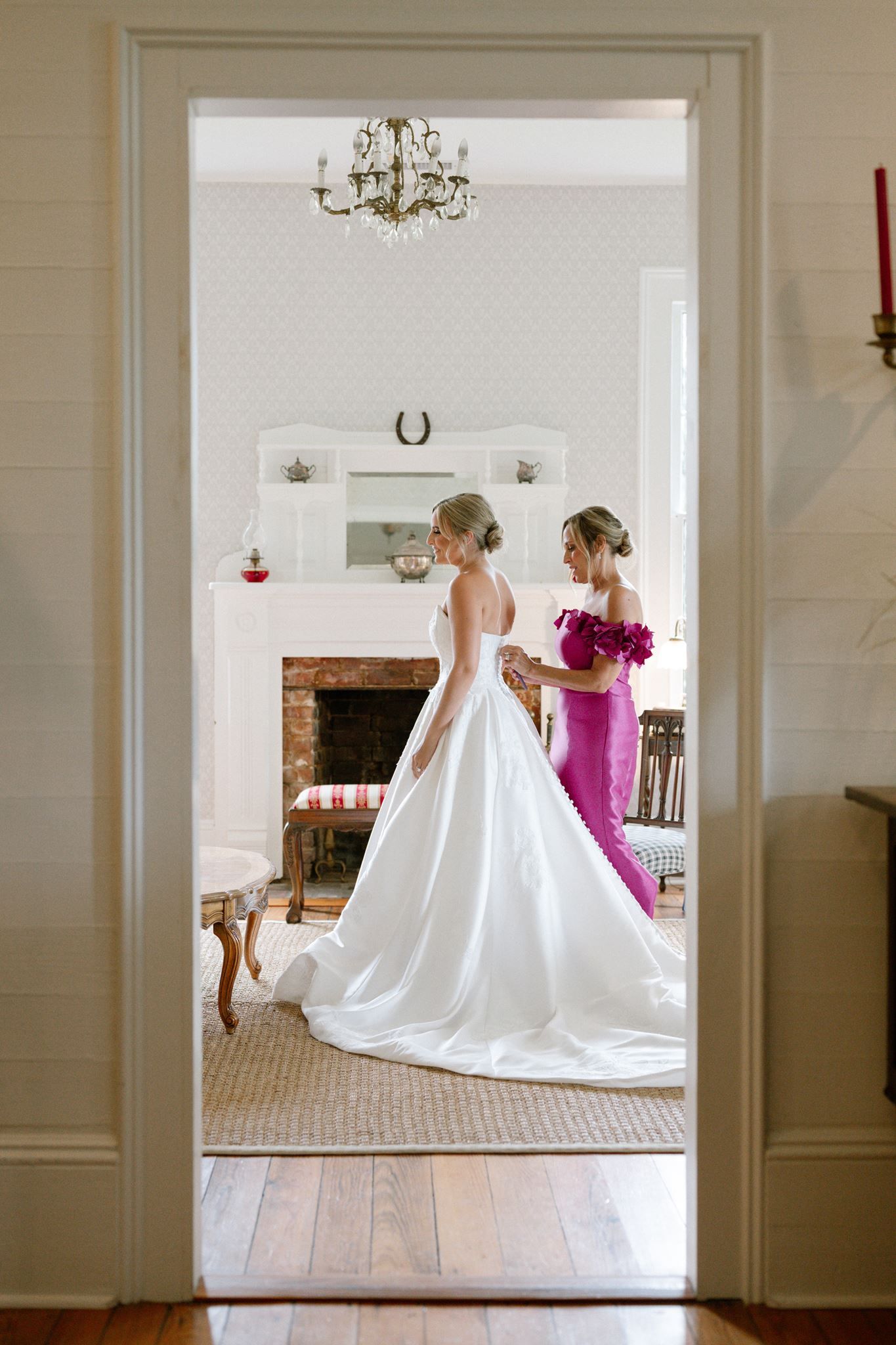 Mother of the bride zipping the bride at Historic Hill House in Willis Texas.