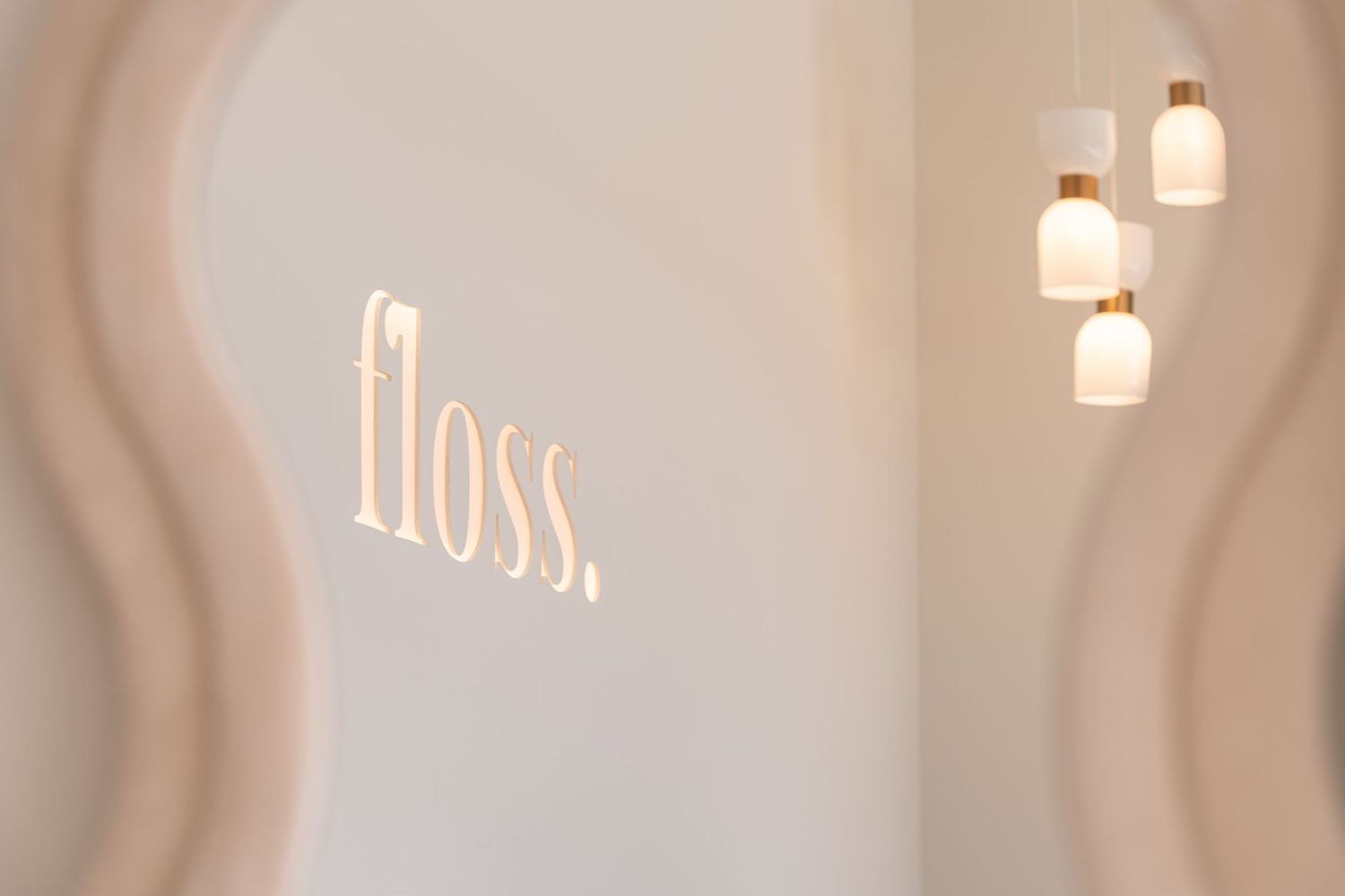 Esthetician wearing pink gloves performs facial treatment on relaxed client at spa.
