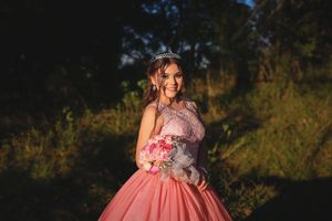 Pink princess gown photographed against dramatic evening sky.