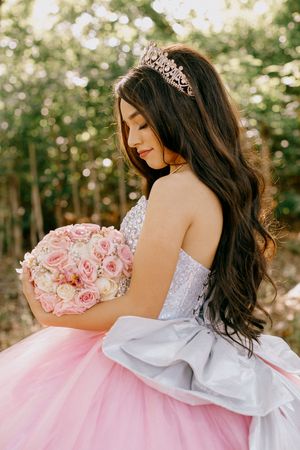 Romantic bridal portraits with pink roses and a delicate tiara against a garden backdrop.