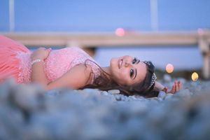 Dreamy portrait of pink gown against blue bokeh lights.