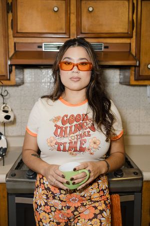 Lifestyle photos in a kitchen with retro-inspired orange and floral fashion.