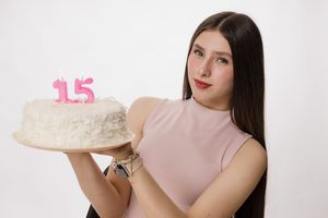 Birthday themed photoshoot with a white cake displaying pink number decorations.