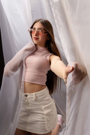 Fashion editorial series with beige turtleneck top and white pants against sheer curtains.