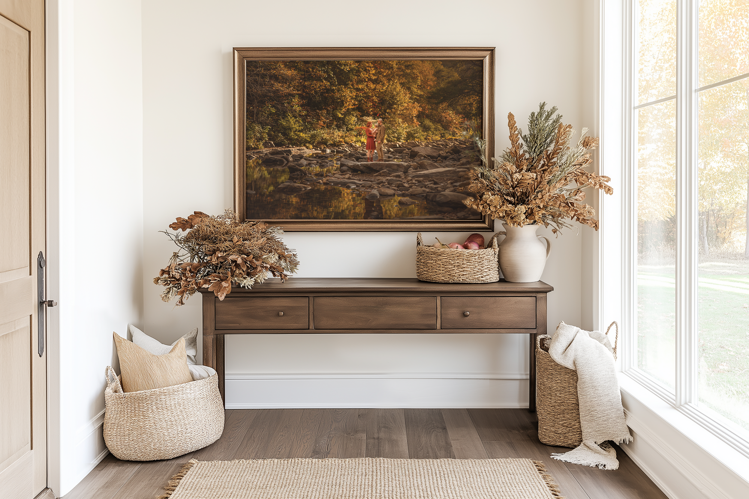 Rustic entryway console table with dried floral arrangements, woven baskets, and a framed autumn landscape painting above.