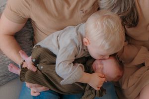 Big sibling holding newborn baby - In-home lifestyle family and newborn photoshoot by Gesiel Martin