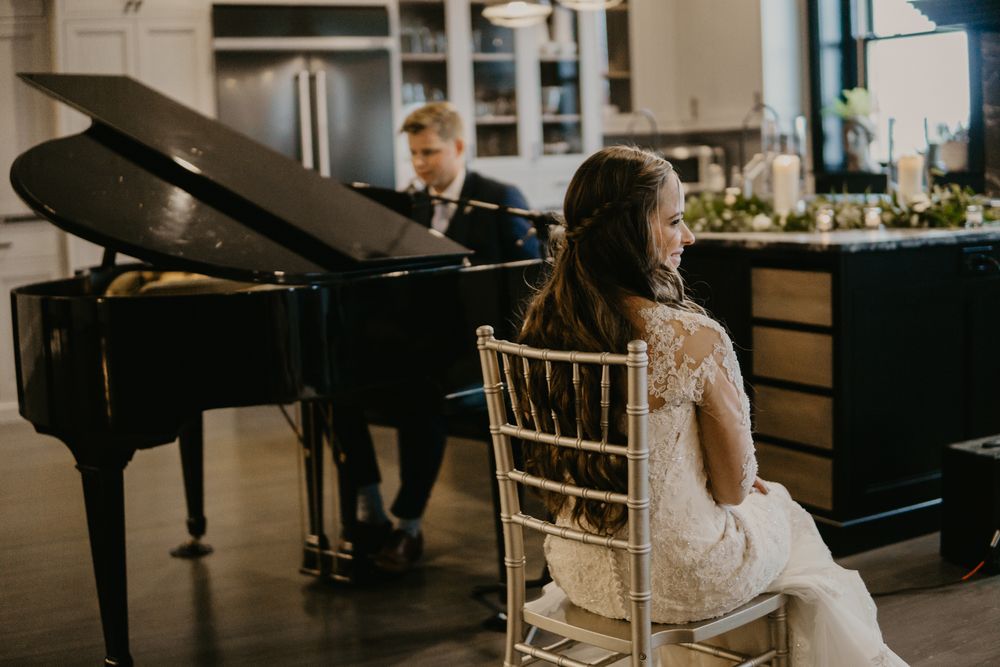 Bride sitting on chair being listening to groom play piano, maryville tennessee