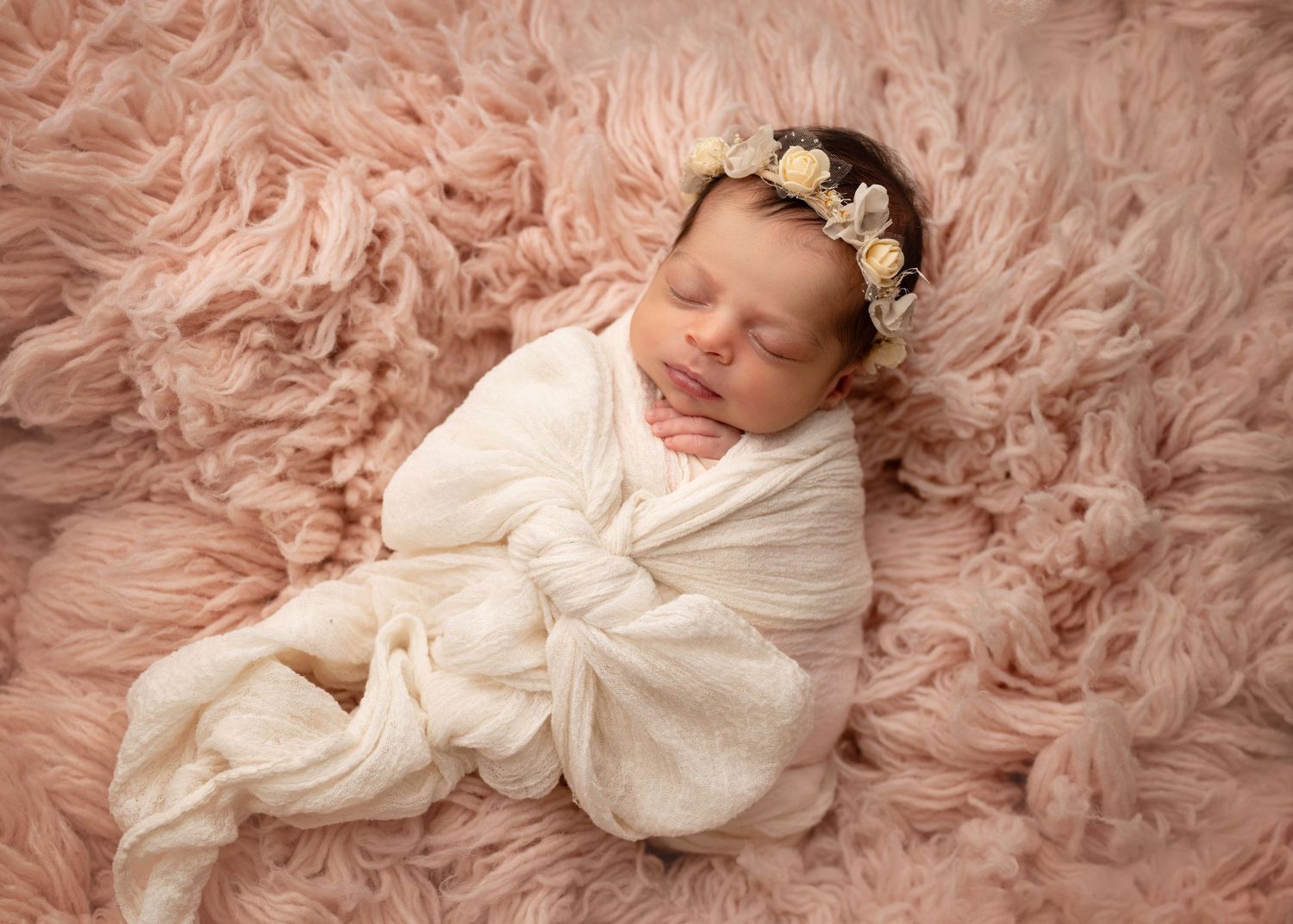 Sleeping newborn baby wrapped in cream during a posed studio newborn photography session in Linden, New Jersey.