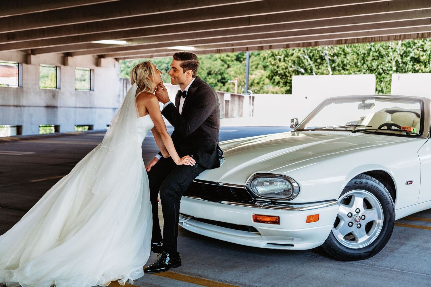 Bride goes in for a kiss on their vintage Jaguar for an elopement in Morgantown, WV