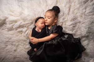 Big sister & newborn baby sister wearing black posed on white fur newborn photoshoot; Lexington, SC newborn photographer