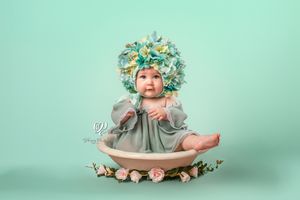 Baby girl sitter session photoshoot; baby girl wearing flower bonnet; professional children's photographer Lexington, SC