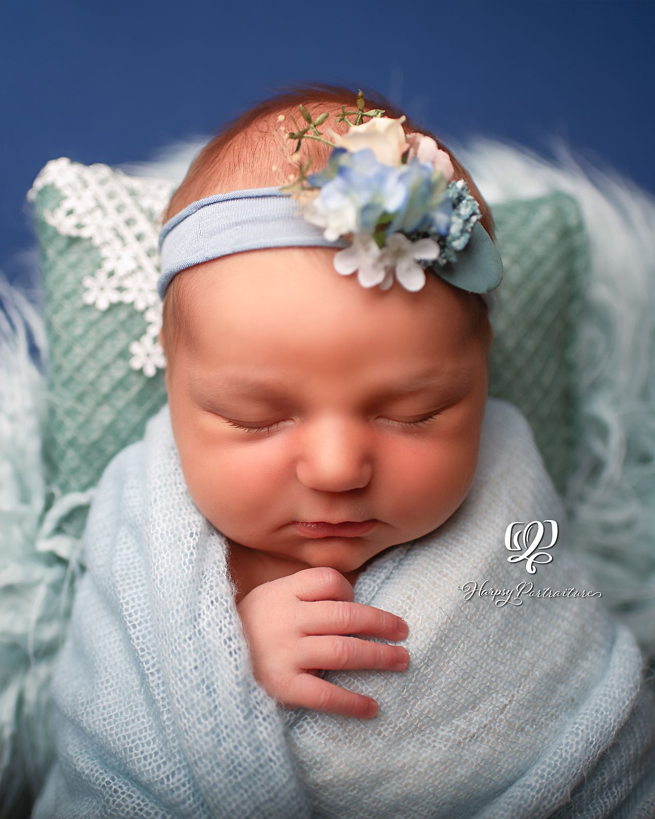Newborn baby girl wrapped in light blue with blue backdrop; newborn photographer Lexington, SC; best photographer SC