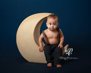 fine art children's photographer Lexington, SC; best photographer Lexington, SC; baby boy posed sitting on moon prop in overalls; child pics