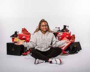 Senior girl photoshoot Lexington, SC; portrait studio Senior session with girl posed with assortment of sneakers in professional studio