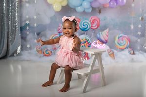 Cake Smash photoshoot first birthday session with pastel candy colors, balloons, clouds; best professional photographer Lexington, SC