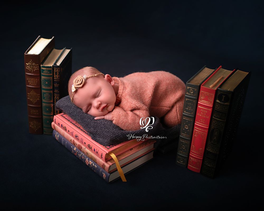 newborn photo baby girl posed sleeping on vintage antique books; best photographer Lexington, SC; newborn photographer South Carolina