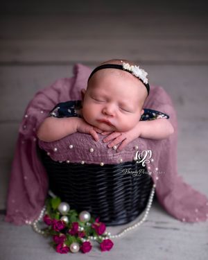 professional newborn photographer Lexington, SC; baby girl newborn posed in basket with flowers & pearls; newborn photographer Lexington, sc