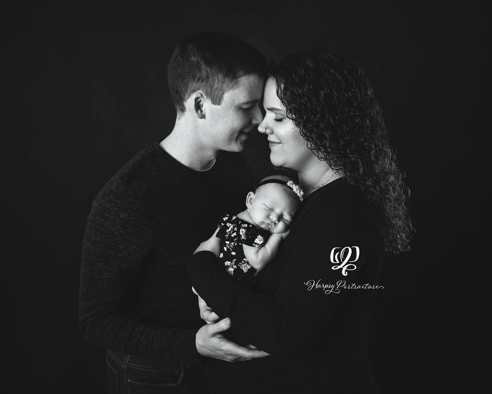 Black & white professional family portrait with newborn daughter; black backdrop, family wearing black; best photographer Lexington, SC