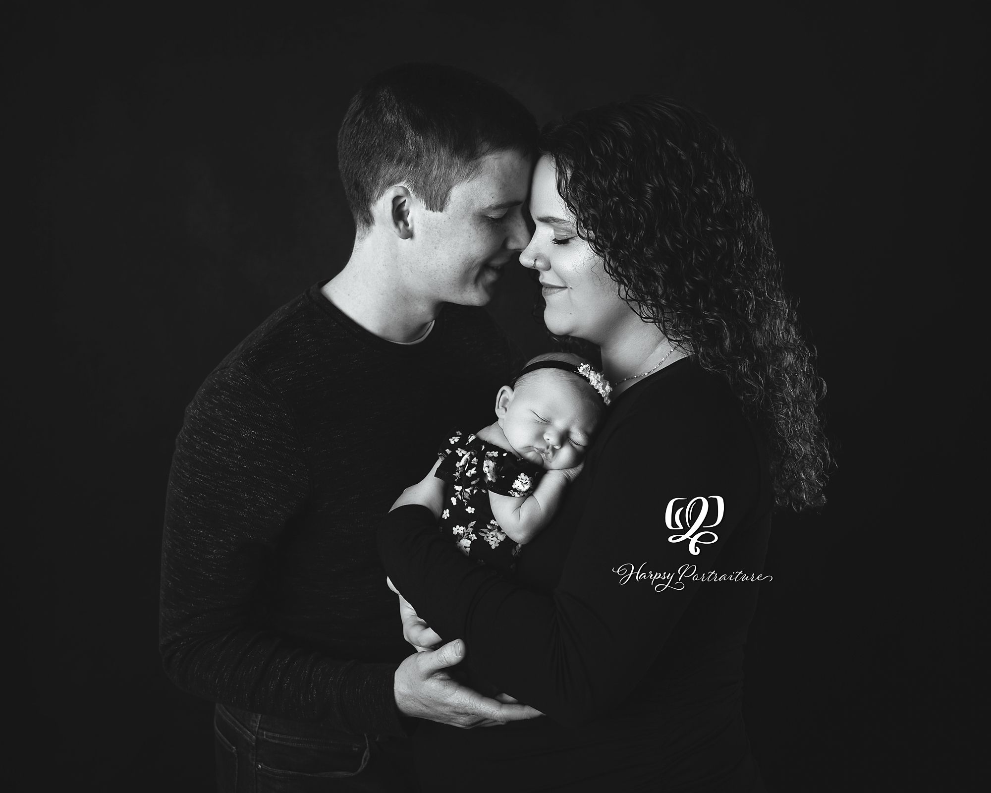 Black & white professional family portrait with newborn daughter; black backdrop, family wearing black; best photographer Lexington, SC