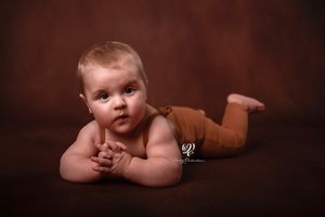 Baby boy's 6-month photoshoot; best children's photographer Lexington, SC; baby posed on belly with hands folded together; fine art portrait