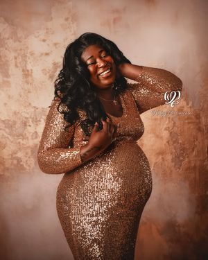 Maternity session photoshoot with pregnant mother wearing gold sequin gown in professional photography studio Lexington, SC