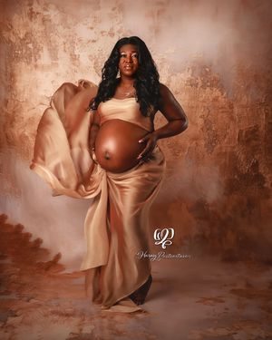 Stunning pregnant mama wearing gold fabric with floating train professional portrait studio maternity session in Lexington, SC photoshoot