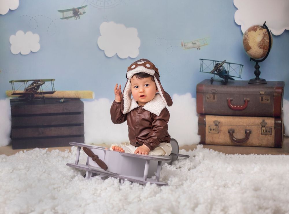 Vintage aviation themed photo setup with toy planes and cotton cloud decorations.