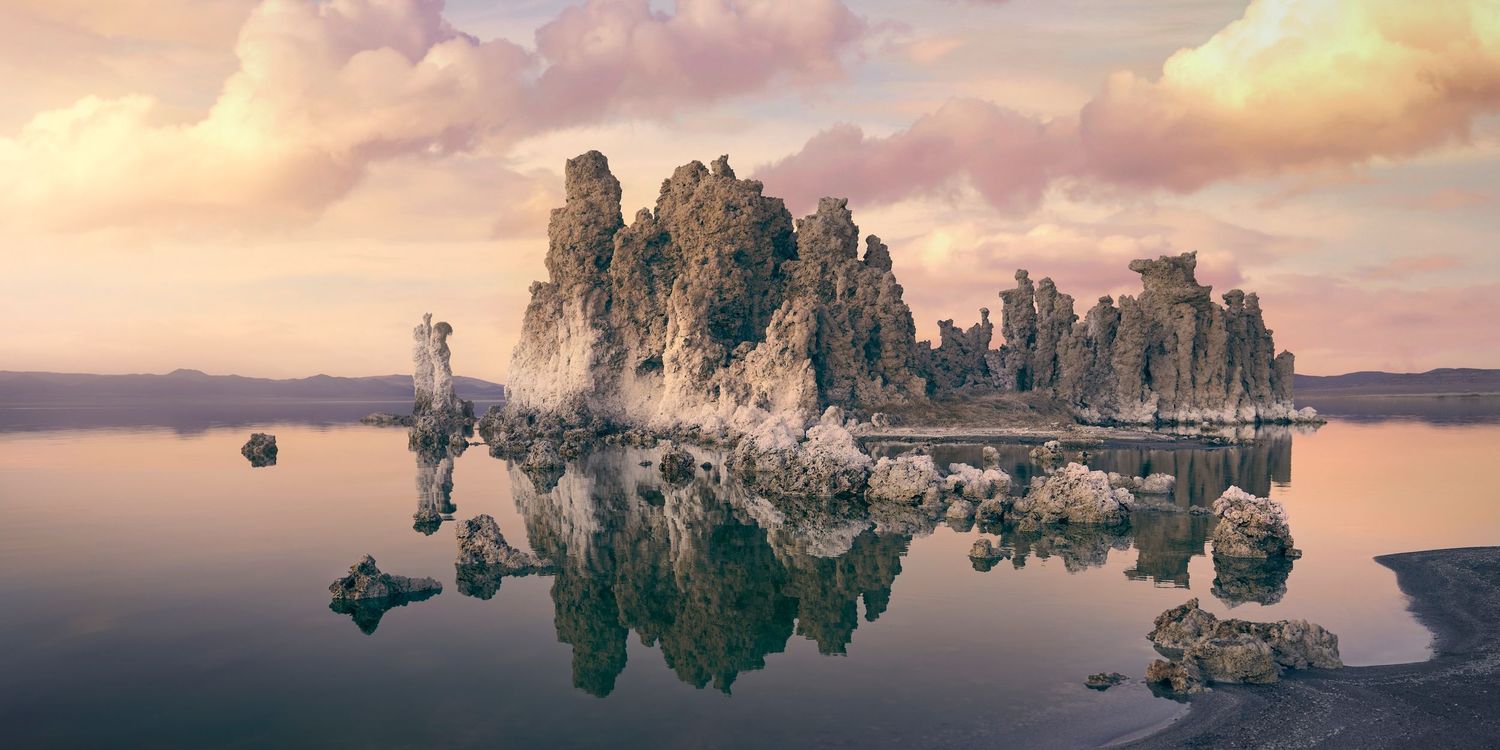 Panoramic view of limestone tufa towers reflecting in the calm waters of Mono Lake, California at sunset photographed by Evan Will
