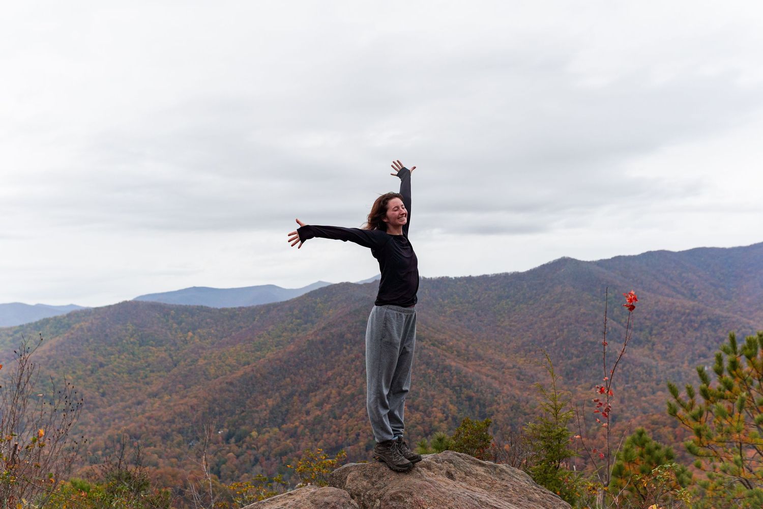 A series of panoramic shots showing someone jumping and posing against a backdrop of colorful autumn mountain landscapes.
