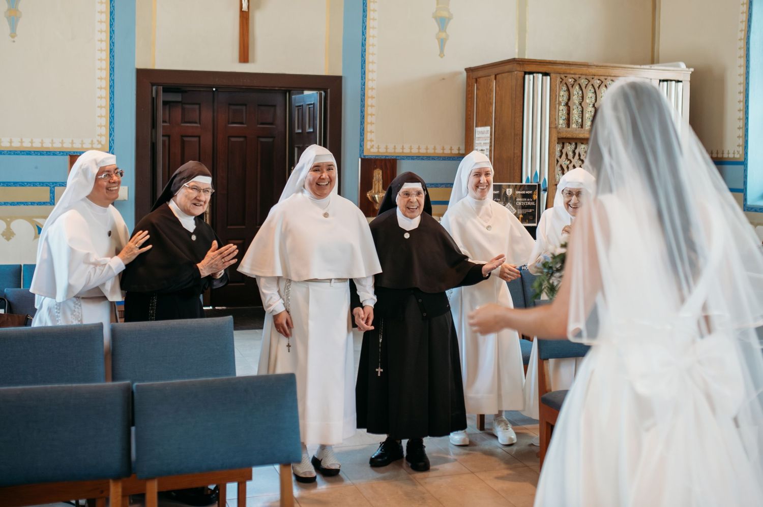 Religious figures in black and white habits gather to celebrate at a formal ceremony in a church setting.