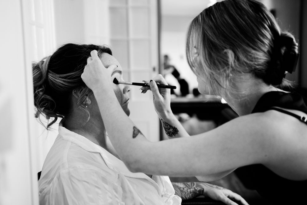 Bride and bridesmaids share emotional hugs and moments while getting ready for the wedding in black and white.