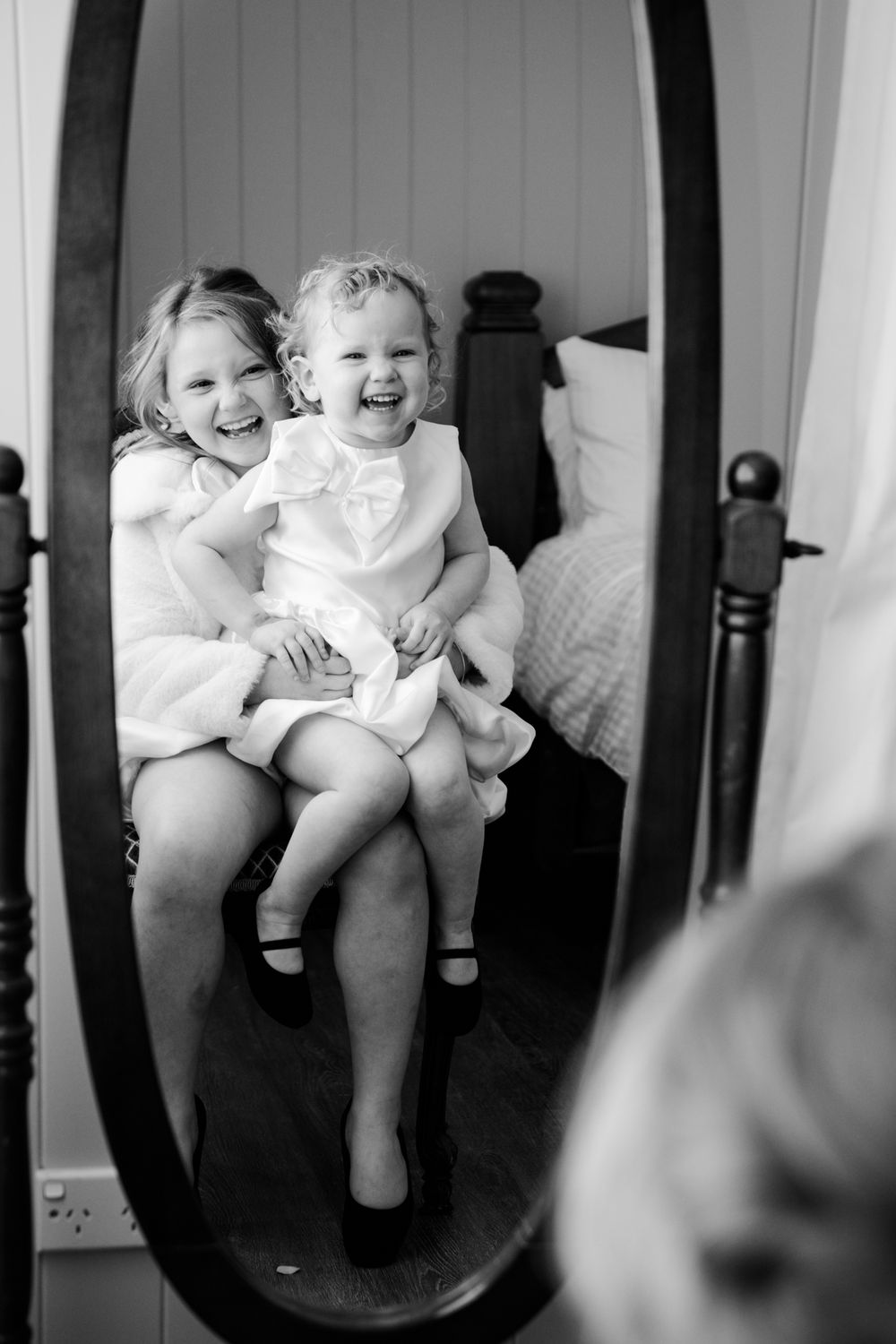 Black and white sequence of joyful laughing moments captured through window frames on a rustic porch.