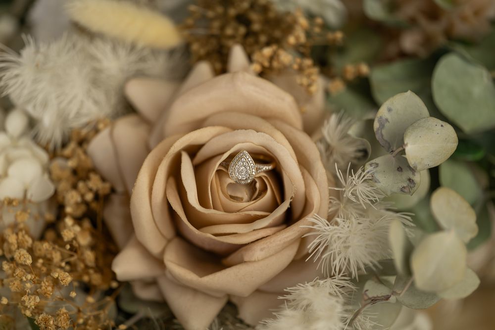 Elegant beige roses and dried flowers arranged in a delicate neutral-toned wedding bouquet with eucalyptus foliage.