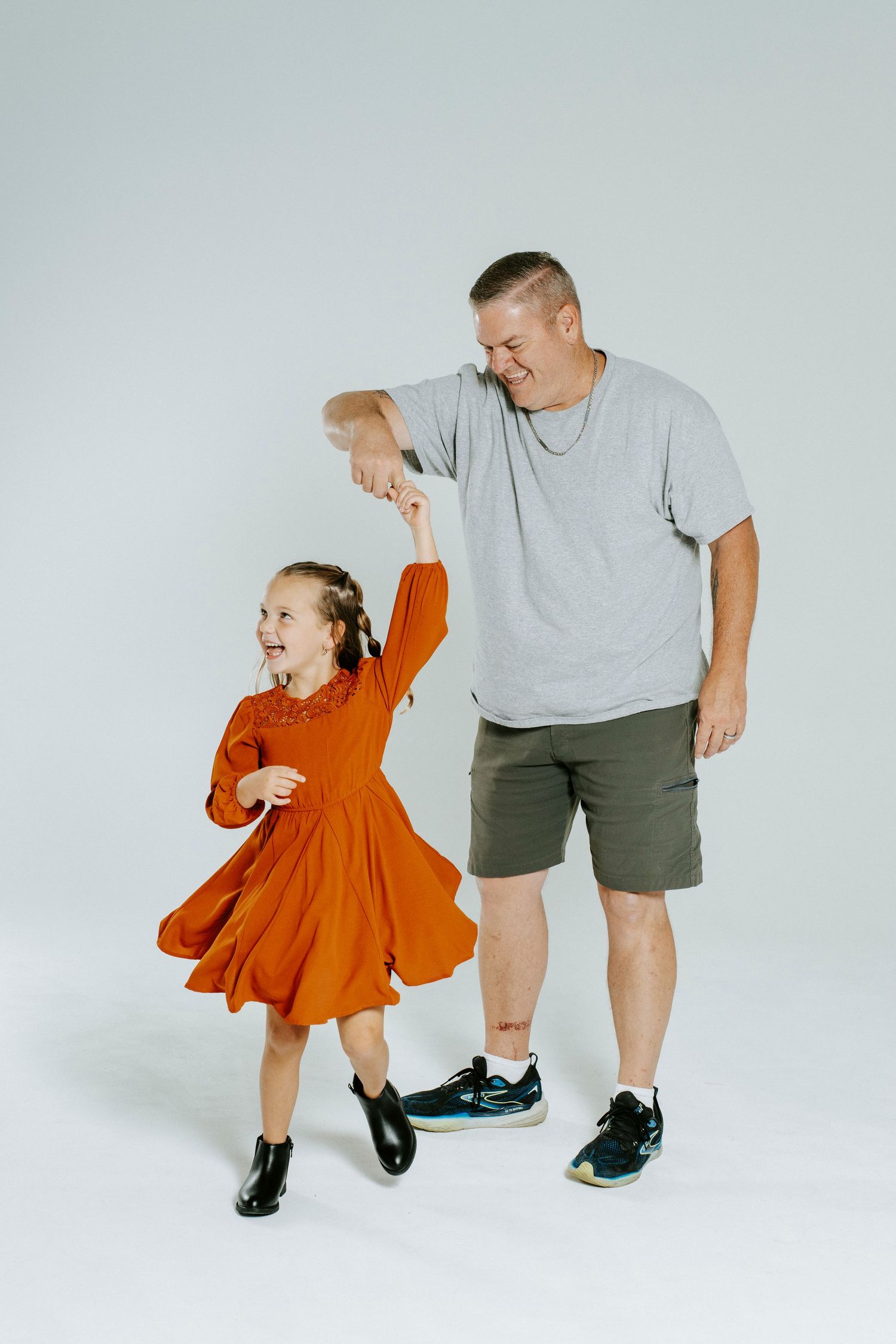 A series of shots showing an adult and child dancing together in casual attire against a white backdrop.
