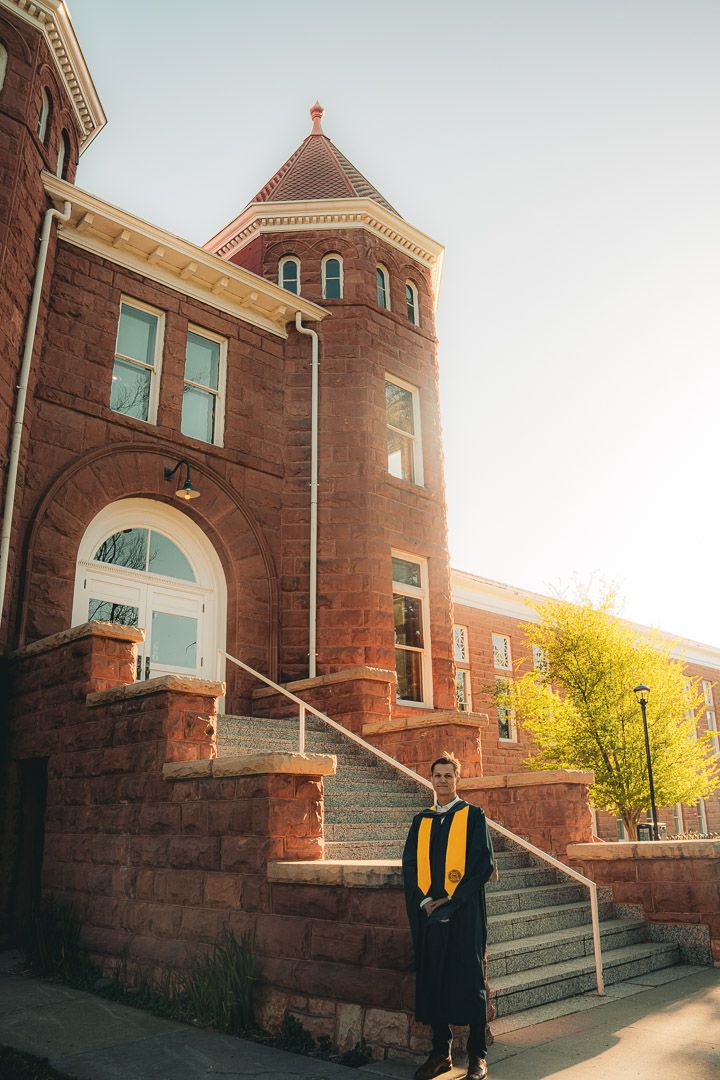 Historical brick church building facade with stone steps and arched entrance in warm sunlight.