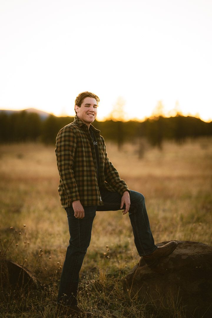 Portrait session in field at sunset with natural lighting and rustic setting.