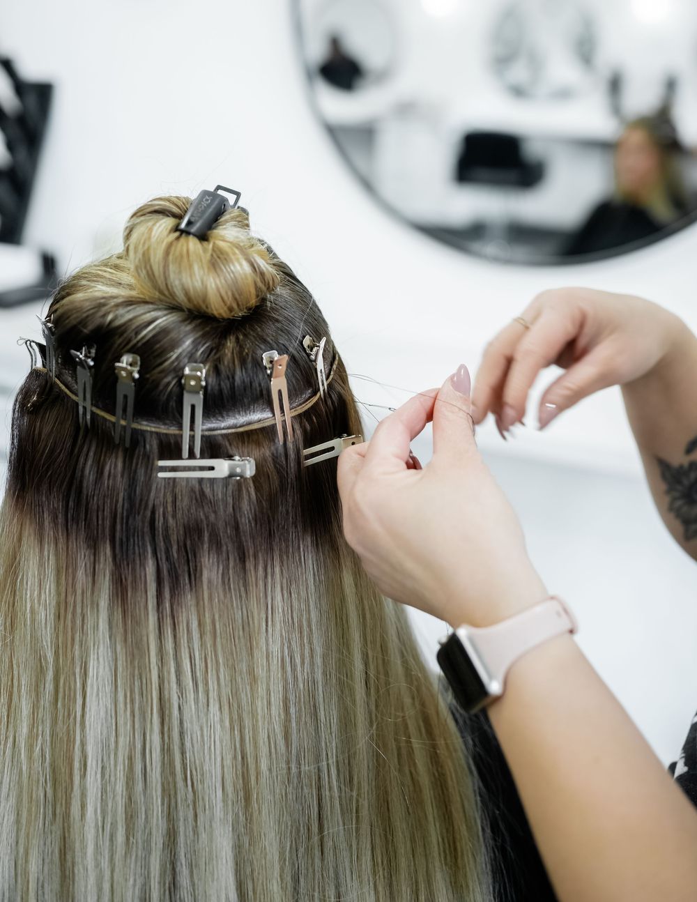 Close-up of hair extension application process showing clip-in technique.