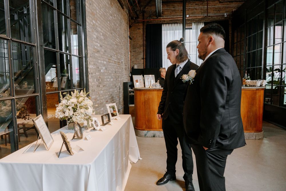 Guests and attendees are gathered in an industrial-chic venue space with exposed brick walls and modern decor.