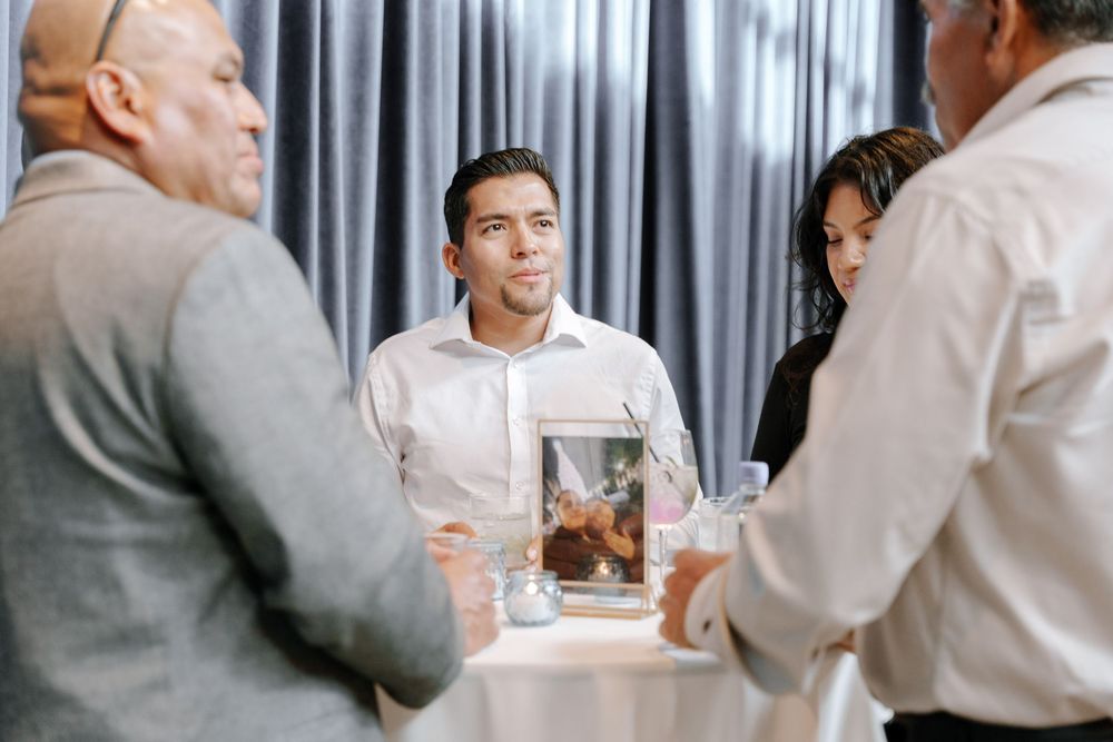 A series of black and white photos showing people sitting and interacting in an office or business setting.
