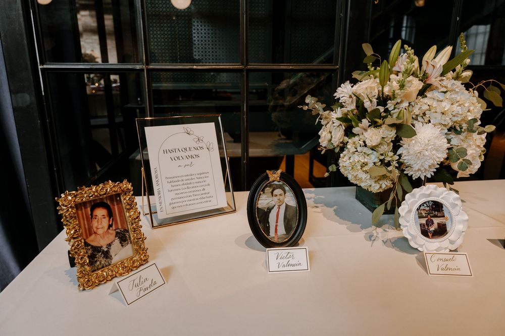 White floral centerpieces and table settings are elegantly arranged on tables at a formal event venue.