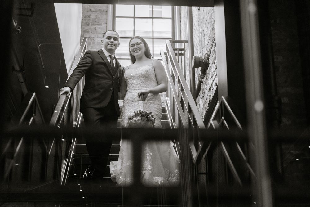 A dark silhouetted scene of people viewed through window blinds or slats.