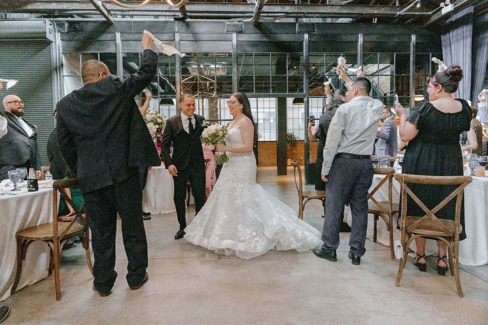 Rustic industrial wedding reception venue with exposed brick walls and wooden chairs set up for a celebration.