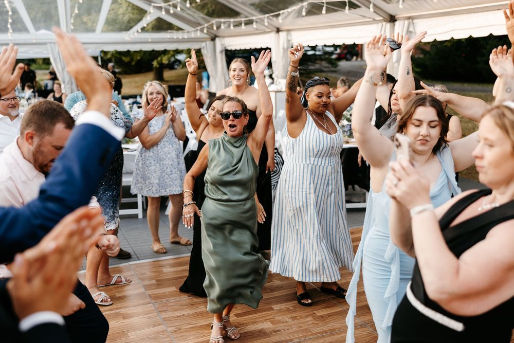 Dancers move energetically in an indoor dance class while wearing casual activewear and workout attire.