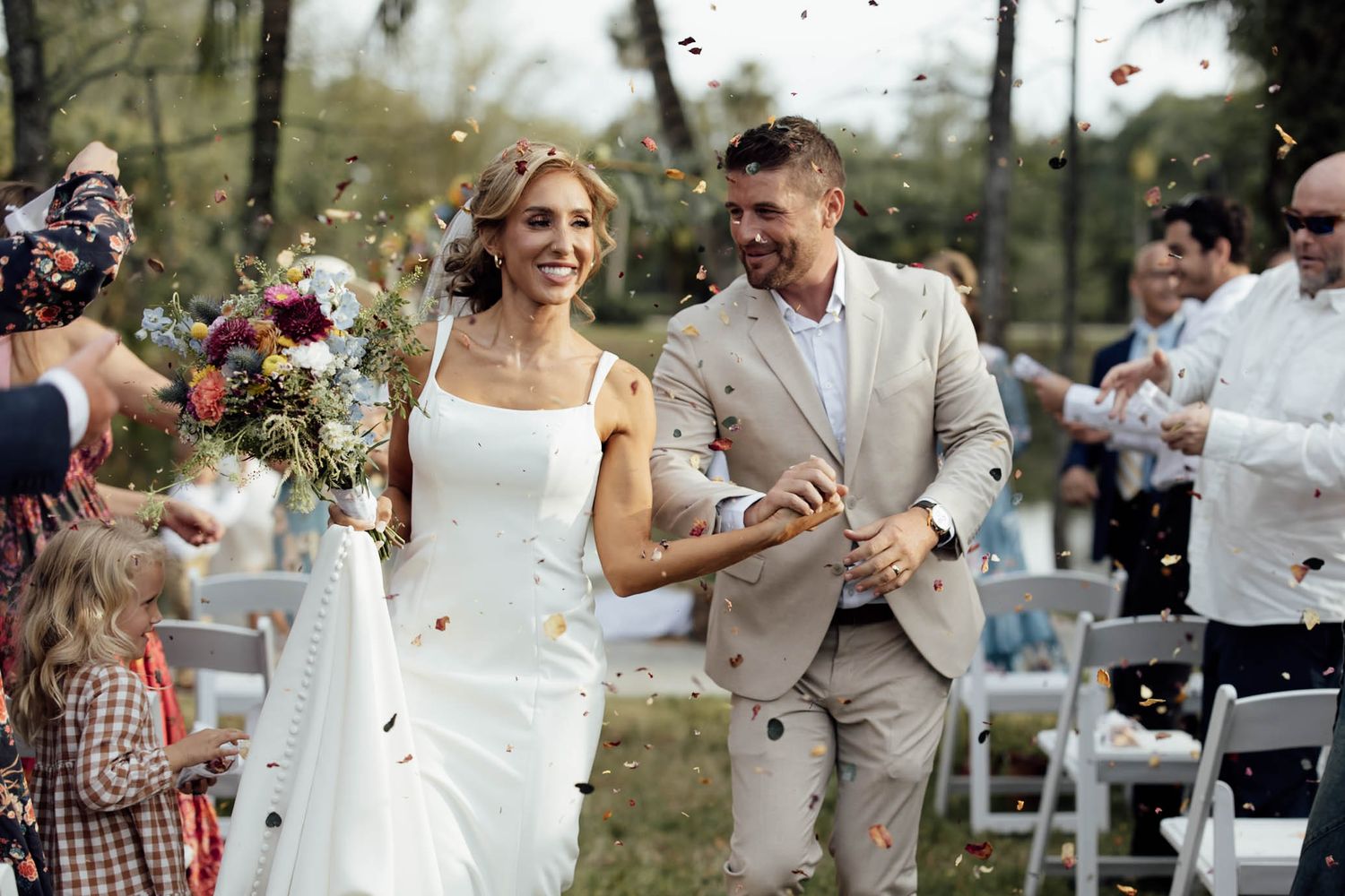 An elegant winter wedding reception features romantic white floral decor and candlelight in a grand venue setting.