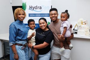 Group of attendees gathered together smiling at a corporate event with HydraTech branding visible.