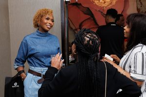 Attendees networking and conversing at an indoor professional event with HydraTech banner visible.