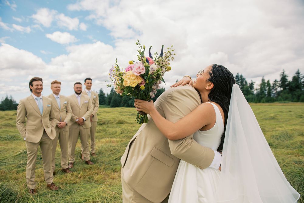 Wedding couple shares intimate moment during outdoor photo session with floral bouquet.