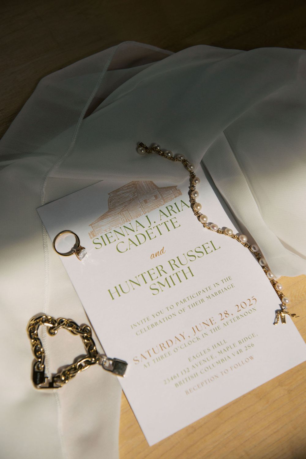 Elegant wedding invitation with jewelry details on white paper.