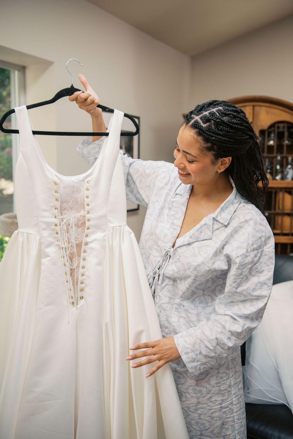 White wedding dress on hanger being examined in preparation for the big day.